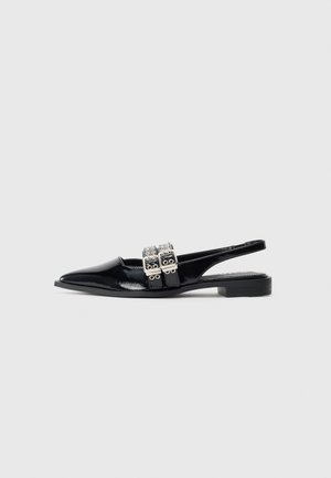 Sorte patent lær flat slingback sko med spiss tå og doble sølvspenner over vristen.