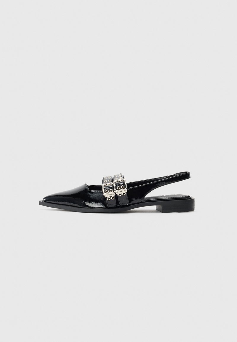 Musta patentoitu nahkainen tasapohjainen slingback-kengät, jossa on teräväkärkinen muoto ja kaksinkertaiset hopeiset soljet jalkapöydän kohdalla.