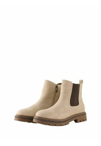 Bottines en daim beige avec une fermeture éclair sur le côté, des panneaux élastiques et une semelle en caoutchouc brun avec un motif texturé.