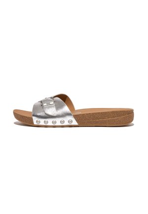 Silver metallic slide sandals with a wide strap, featuring a rectangular buckle and decorative stud accents on a cork sole.