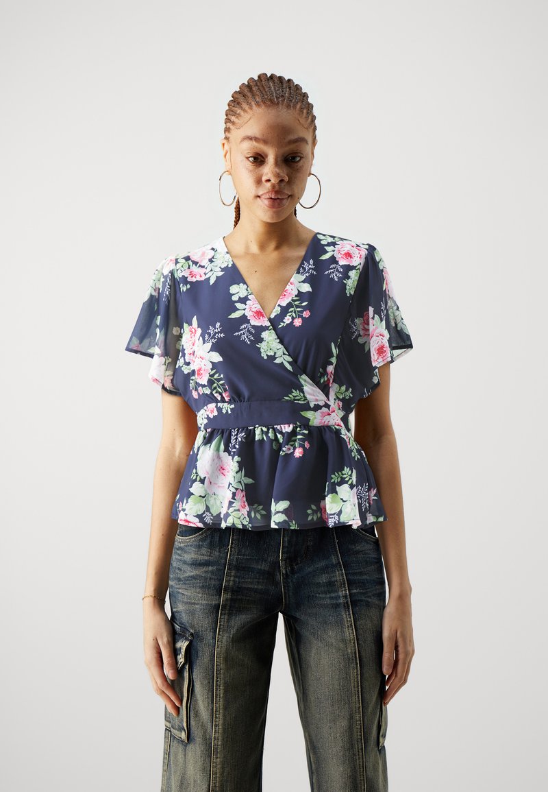 Marine blomstrete peplum-top med korte flatterende ermer, med nyanser av rosa og grønne blomster, v-hals og samlet midjedetalj.