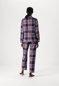 Paarse en marineblauwe geruite pyjama set gemaakt van zachte stof, met een lang mouwtop en loszittende broek met een elastische tailleband.