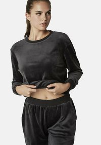 Grijze fluwelen sweatshirt met een ronde halslijn en lange mouwen, voorzien van ribgebreide manchetten en een cropped pasvorm, gecombineerd met bijpassende broek.