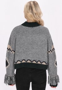 Gekürzter grauer Pullover aus gestricktem Stoff mit einem dunkelgrünen gerippten Kragen. Verfügt über gemusterte Akzente, lange Fransenärmel und dekorative Details.