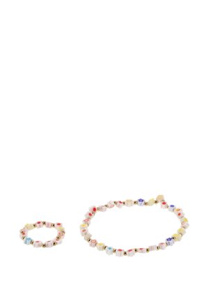 Fehér, virág alakú gyöngyökből készült karkötő és gyűrű, színes középpel és apró arany gyöngyökkel, fehér háttéren.