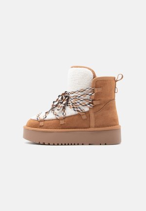 Brown suede ankle boot with white fleece lining, thick brown sole, and multicolored braided laces; features pull tab on the heel.