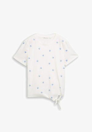 T-shirt blanc à manches courtes avec petits motifs coquillages bleus et un nœud sur le côté devant de l’ourlet.