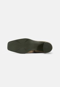 Shoe sole in green rubber with a textured finish. Features a squared shape with angular patterns and minimalistic design elements.