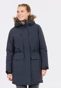 Marineblaue Parka mit einer Kapuze aus Kunstfell, einem Reißverschluss auf der Vorderseite, einem Kordelzug in der Taille und zwei großen Fronttaschen. Verfügt über eine weiche Textur.