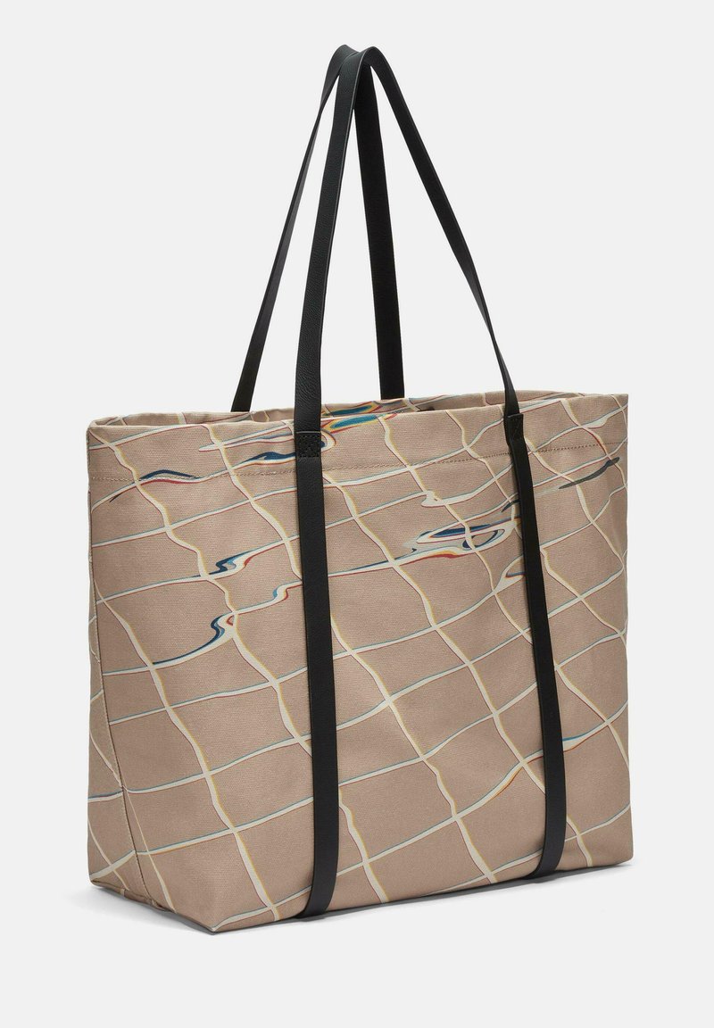 Beige Canvas-Tasche mit schwarzen Trägern, versehen mit einem Rautenmuster in Blau und bunten Linien, und einer geräumigen rechteckigen Form.