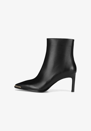 Mustad nahast pahkluu saapad terava nina, õhuke kõrge konts ja minimalistik disain. Omab kuldset aktsenti ninaosas ja sileda tekstuuri.