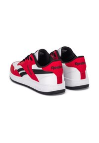 Punase, mustad ja valged Reebok'i tossud madala disainiga. Tekstuuriga sünteetiline ülaserv, pehmendatud kaelus ja kummist välistald.