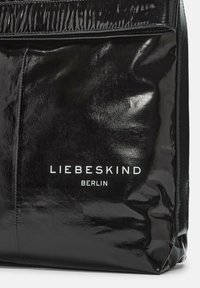 Borsa in pelle verniciata nera con un design elegante. Presenta il logo "LIEBESKIND BERLIN" in bianco, evidenziato da una texture lucida.