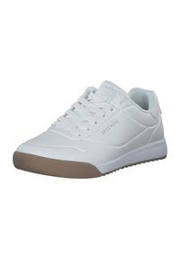 Sneaker de sport blanc avec une tige synthétique lisse, des accents texturés et une semelle en caoutchouc beige. Présente un design à lacets et des détails perforés.