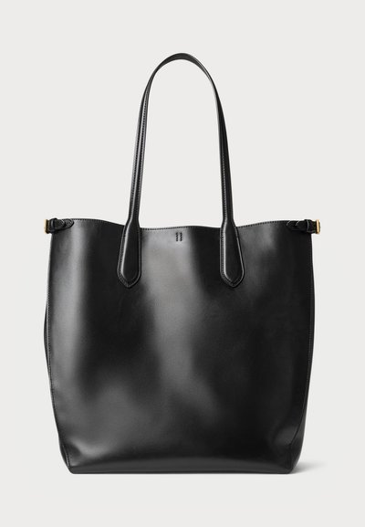 Μαύρη δερμάτινη τσάντα tote με δύο μακριές λαβές, λεία υφή, μινιμαλιστικός σχεδιασμός, ανοιχτό πάνω μέρος και μία μικρή χρυσή λεπτομέρεια σε μία πλευρά.
