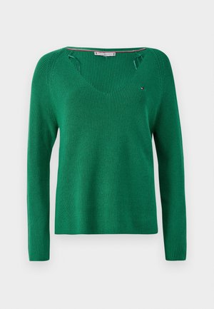 Green knitted sweater with long sleeves, V-neck, and cut-out detailing at the shoulders. Features a small logo accent.