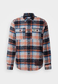 Camicia a quadri da uomo in misto lana. Presenta un motivo a quadri arancione, blu e nero, taschini frontali, bottoni neri e un'etichetta in tessuto sull'orlo.