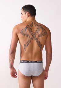 Herren graue Baumwollslips mit einem schwarzen elastischen Bund, der das Branding "PIER ONE" trägt, getragen von einem Modell, das ein detailliertes Rückentattoo zeigt.