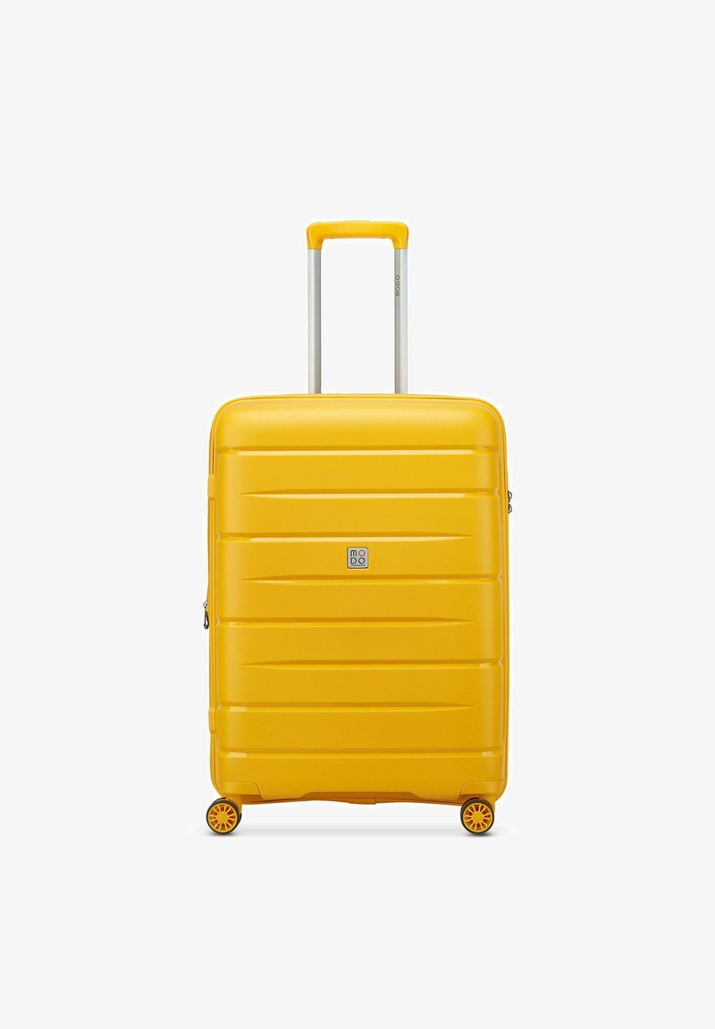 Maleta rígida amarilla con surcos horizontales, mango extensible plateado y cuatro ruedas para movilidad. Presenta un pequeño logotipo de la marca.
