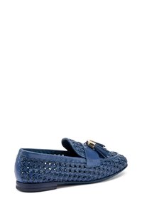Mocassini blu in pelle con texture intrecciata, dettagli con nappina e accentature in oro. Suola piatta e design con punta arrotondata.
