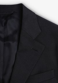 Blazer entallado de un oscuro azul marino que muestra la solapa, el ojal y el suave forro interior.