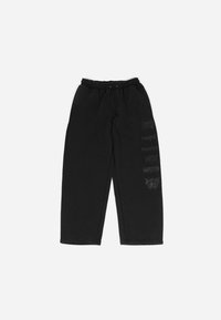 Svart joggebukser med elastisk midje og snøring. Klistremerker i mørkegrå på venstre ben. Mykt, uformelt stoff.