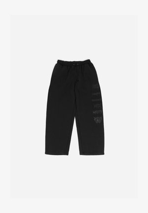 Svart joggebukser med elastisk midje og snøring. Klistremerker i mørkegrå på venstre ben. Mykt, uformelt stoff.