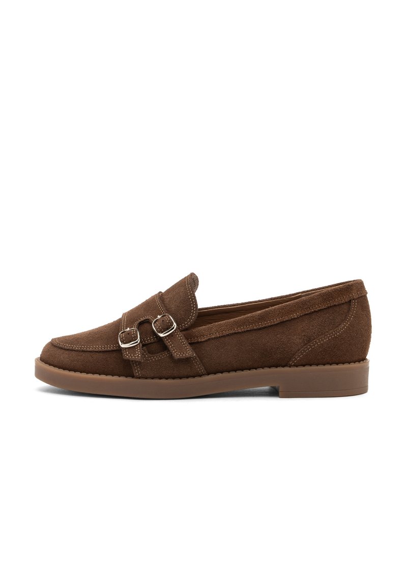 Mocassino in suede marrone con doppie fibbie in argento, dettagli cuciti e suola in gomma marrone bassa.