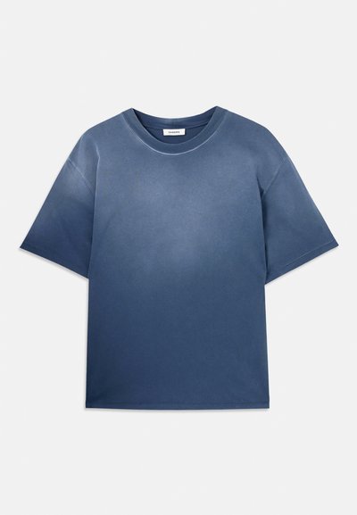 Modra bombažna majica s sproščenim krojem, kratkimi rokavi, okroglo izrezom in mehko teksturo. Ima postopno barvno učinek bledela.