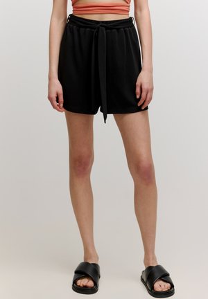 Zwarte shorts met een trekkoord in de taille, een gladde textuur, een ontspannen fit en een lengte tot halverwege de bovenbenen. Draagt met zwarte sliders.