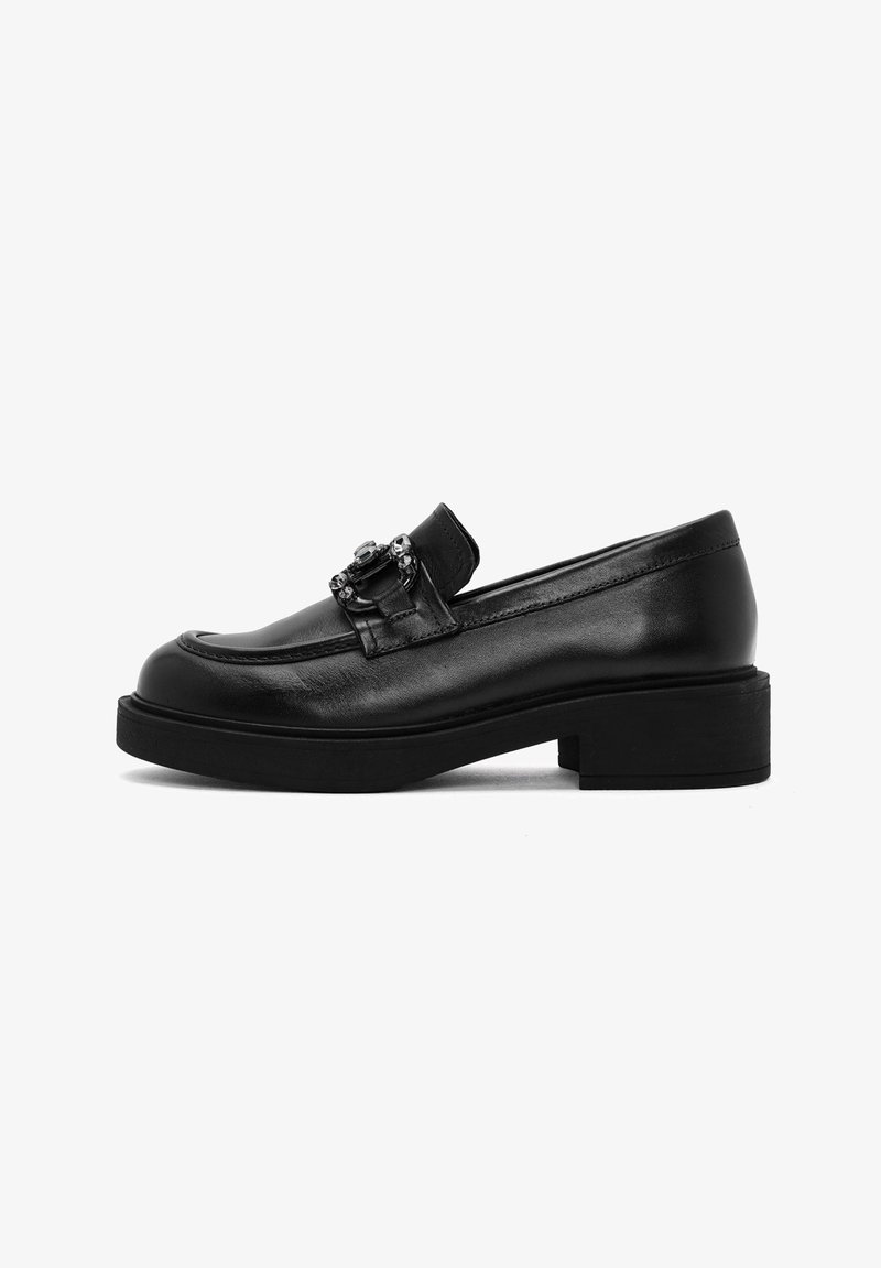 Mocasines de piel negra con un bajo tacón cuadrado, que presentan un acento decorativo de hebilla y una superficie lisa con detalles de costura mínimas.