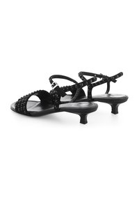 Zwarte hoge hak sandalen met studaccenten, voorzien van een gestructureerd bandontwerp, open teen en een lage blokhak voor stabiliteit.