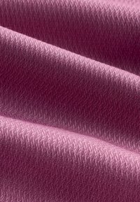 Gewebter Stoff in zartem Rosa mit einem strukturierten Muster aus diagonalen Linien. Das Material wirkt glatt und zeigt in einigen Bereichen einen leichten Glanz.