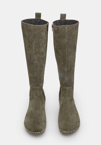 Olīvu zaļas zamšādas ceļgalu augstās zābaki ar sānu rāvējslēdzējiem, noapaļotiem pirkstiem un teksturētu pelēku oderi. Gluda apdare un minimāla dūru šuvju akcenti.