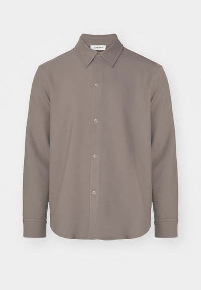 Langærmet skjorte med krave i et dæmpet brunt materiale, som har knaplukning fortil, rundet kant og en glat tekstur med minimal detaljering.