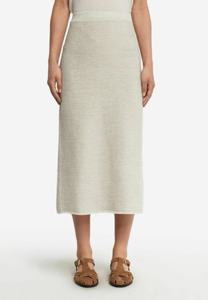 Gonna midi in maglia color beige chiaro con un motivo testurizzato, dotata di una vita aderente e una silhouette dritta, abbinata a sandali marroni.