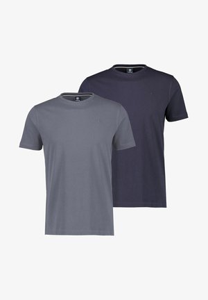 Dunkelblaues T-Shirt mit kurzen Ärmeln aus weichem Stoff, mit rundem Ausschnitt und kleinem Logo auf der Brust, kombiniert mit beigen Hosen.