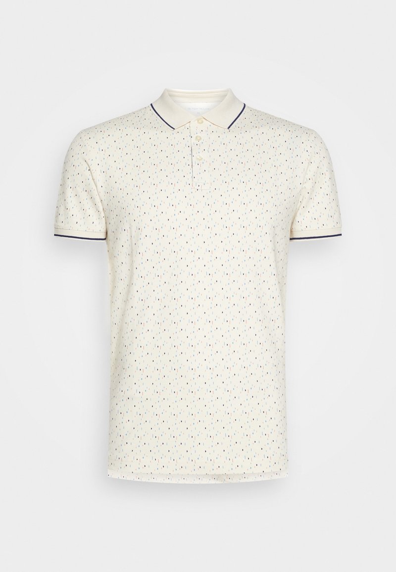 Polo crème à manches courtes avec un petit motif à pois multicolores et une bordure foncée au col et aux bords des manches.