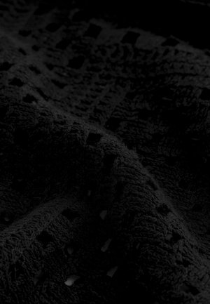 Tessuto nero texturizzato con una superficie soffice simile a un asciugamano che presenta un motivo di quadrati perforati e linee orizzontali.