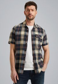 Chemise à manches courtes à carreaux dans des couleurs marine, beige et rouille ; présente un devant à boutons et une poche poitrine ; fabriquée en tissu léger.