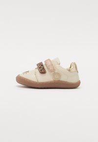 Beige színű gyerekcipő tépőzárral, leopárdmintás és csillogó részletekkel, kerek orral, lekerekített háttal és texturált gumitalppal.