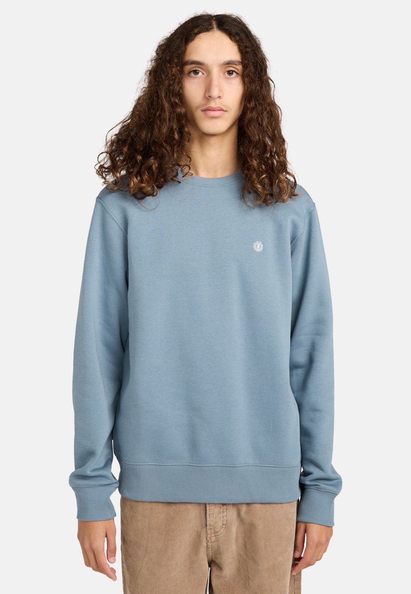 Sudadera azul claro hecha de tela suave, con puños y dobladillo acanalados, y un pequeño logo bordado en el pecho.