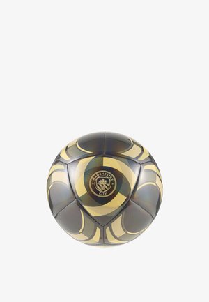 Ballon de football noir et or brillant avec le logo de Manchester City et des motifs décoratifs circulaires et courbes.