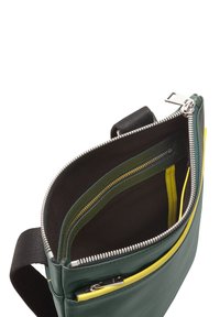 Grüner Leder-Tascheninnenraum mit schwarzem Stofffutter, mit einer gelben Reißverschlusstasche und Fächern zur Organisation. Silberne Hardware-Akzente.