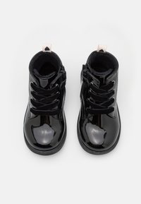 Sorte, patentlær ankle boots med snøring foran, glidelås på siden, myk innside og lite hjertelogo på bakre trekksnor.
