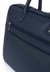 Marineblauwe nylon tas met een gladde textuur, dubbele handvatten, een voorzak met rits en een vlak paneel, met metallic accenten en een gestructureerd ontwerp.