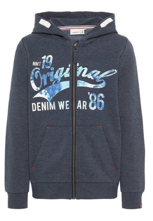 Marineblauwe zip-up hoodie gemaakt van zachte stof met een ontwerp aan de voorkant met blauwe en witte graphics. Inclusief twee voorzakken en een capuchon.