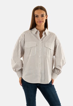 Camicia a righe in crema e marrone, dotata di due tasche sul petto, maniche ampie e colletto classico. Tessuto morbido e vestibilità rilassata.