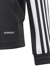Schwarzes Sportshirt mit weißen Streifen, aus strukturiertem Stoff und mit dem "AEROREADY"-Logo nahe dem Saum. Entwickelt für Feuchtigkeitsmanagement.