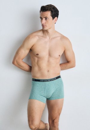 Türkisfarbene Boxershorts mit strukturiertem Muster, ausgestattet mit einem schwarzen elastischen Bund, der mit "EMPORIO ARMANI" beschriftet ist. Glattes Material, enganliegendes Design.